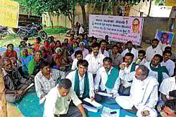 Residents of Vivekanandanagar in Mulbagal stage a protest on Friday against eviction from their huts. DH Photo