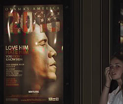 A young lady is seen walking past a promotional poster at the Rave Fairfax Corner movie theater in Fairfax, Virginia, announcing the new movie '2016: Obama's America' that opened in theaters across the US. AFP