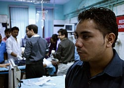 Amarjeet Singh, right, stands guard inside the emergency room at the Deen Dayal Upadhyay Hospital in New Delhi, India. Singh and 20 other bouncers have been hired to protect doctors as well as keep the emergency and labor rooms from filling up with patients often agitated relatives and friends. AP File photo