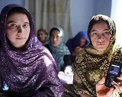 Afghan women sit in a class and study using mobile phones in Kabul on November 3, 2012. Afghanistan has launched a new literacy program that enables Afghan women mostly deprived from basic education during decades of war to learn to read and write using a mobile phone. The phone is called Ustad Mobile (Mobile Teacher) and provides a national curriculum courses in both national languages, Dari and Pashtu, as well as mathematics. AFP PHOTO