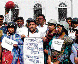 Congress MLAs wear helmets during a protest over Tuesdays clash between CPM and Trinamool Congress MLAs in the Assembly, in Kolkata on Wednesday. PTI