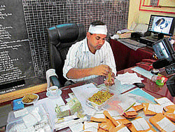 The Booty: Superintendent of Police Sandeep Patil examines gold bars and ornaments seized from three men in Belgaum on Friday. dh photo