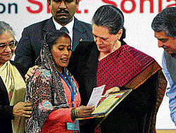 UPA chairperson Sonia Gandhi presents Aadhar ATM card to a beneficiary at the launch of Dilli Annashree Yojna in New Delhi on Saturday. PTI