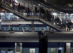 New Delhi: Passengers walk as trains wait to run at a train station in New Delhi on Wednesday. Railways Minister Pawan Kumar Bansal announced across the board hike in fare of all classes for the first time in ten years. PTI Photo