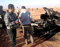 In this undated photo, men look at the wreckage of a vehicle near Ain Amenas, Algeria. Algerian bomb squads scouring a gas plant where Islamist militants took dozens of foreign workers hostage found 'numerous' new bodies on Sunday, Jan. 20, 2013 as they searched for explosive traps left behind by the attackers, a security official said, a day after a bloody raid ended the four-day siege of the remote desert refinery. AP