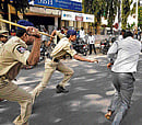 Attack mode:  Police baton a supporter of MIM chief and MP Asaduddin Owaisi (inset) near a court in Sangareddy town of Medak district in Andhra Pradesh on Monday. PTI