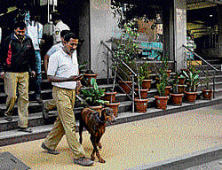 investigation: A dog squad leaves the UG Regal Lodge at Cottonpet where a woman was found murdered, on Wednesday evening. dh Photo