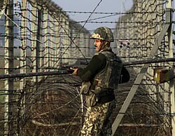 An Indian Border Security Force (BSF) soldier patrols near the fenced border with Pakistan. File Reuters Photo