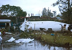 Bystanders look on as peacekeepers secure the wreckage of a crashed plane, in Goma, Congo, Monday, March 4, 2013. A Fokker airplane of the private airline CAA crashed in the city center Monday, killing at least six people onboard. There were no reported casualties on the ground.(AP Photo)
