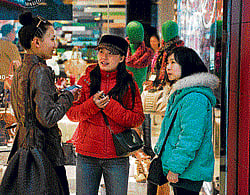 seeking a spouse: Yang Jing, centre, and an assistant, right, talk to a woman about signing up to Diamond Love and Marriage, a matchmaking service, at the open-air mall Sanlitun Village in Beijing. NYT