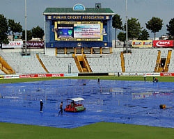 Groundmen clear the pitch for the 3rd Test between India and Australia as rain delayed the match at PCA Stadium in Mohali on Thursday. PTI Photo