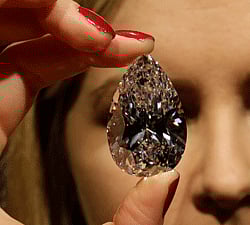 An auction house employee holds a pear-shaped diamond weighing 101.73 carats, as she poses for the photographers in central London, Wednesday, March 13, 2013. Offered for sale for the first time on May 15, 2013 in Geneva, Switzerland by Christie's, the gemstone, one of the largest pear-shaped diamonds known to date, is a D colour, Type IIA Flawless gem. (AP Photo