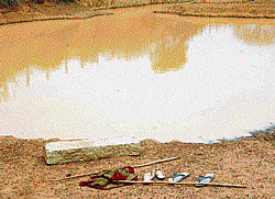 Remnants: Narayanamma and Shobha's footwear and sticks seen on the banks of the water tank at Ajjavara in Chikkaballapur. dh photos