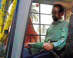 Kolar Deputy Commissioner D S Vishwanath drives the earth mover at N R Chandrashekhars farm at Nenamanahalli on Friday. dh photo