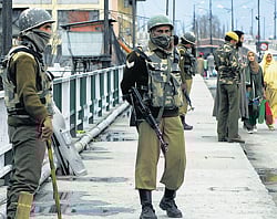 Troubled times: Security personnel stand guard on a street in Srinagar on Sunday. PTI