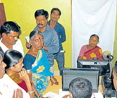 Even on Sunday, people wait to submit ration card applications at the Food and Civil Supplies Department service centre at Kurubarapet in Kolar. DH Photo