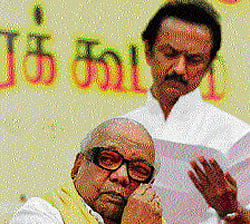 DMK chief M Karunanidhi wipes his face as his son M K Stalin looks at a paper as they attend their party's executive meeting in Chennai on Monday. REUTERS photo