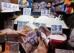 GROWTH POTENTIAL: A customer counts peso bills as she bought half a sack of rice at a store in a public market in Mandaluyong City Metro Manila . REUTERS