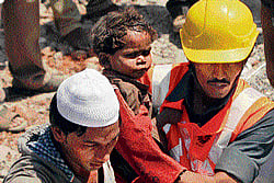 SAVING LIVEs: Rescue work in progress at the site of the collapsed building in Thane, Mumbai on Friday(L). Rescue workers carry a child who survived a building collapse. The half-finished building that was being constructed illegally in a suburb of India's financial capital collapsed on Thursday, killing 56 people and injuring more than 50 others, police said on Friday. Agencies
