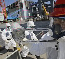 A radiation monitor indicates 114.00 microsieverts per hour near the No.4 reactor (background C) and it's foundation construction (background R) for the storage of melted fuel rods at Tokyo Electric Power Co. (TEPCO)'s tsunami-crippled Fukushima Daiichi nuclear power plant in Fukushima prefecture, March 6, 2013.  Credit: Reuters/