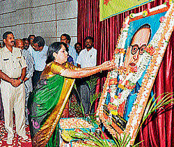 Deputy Commissioner M V Savitri pays floral tributes to portrait of Dr B R Ambedkar in Chamarajanagar.