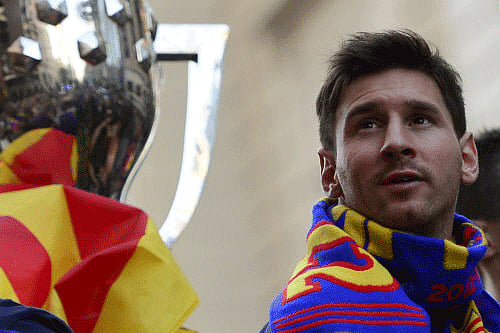 Barcelona's Argentinian forward Lionel Messi (R) reacts as he and his teammates parade on a bus through a crowd of supporters celebrating in the streets of Barcelona on May 13, 2013, two days after their team won the Spanish league. AFP Photo