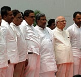 Karnataka Governor Hansraj Bhardwaj and Chief Minister Siddaramaiah with newly sworn-in ministers at the swearing-in-ceremony at Raj Bhavan in Bengaluru on Saturday. PTI Photo