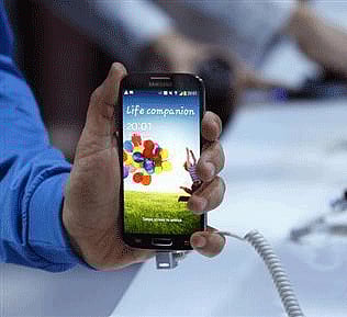 A man holds up Samsung Electronics Co's latest Galaxy S4 phone during its launch at the Radio City Music Hall in New York March 14, 2013. Credit: Reuters/