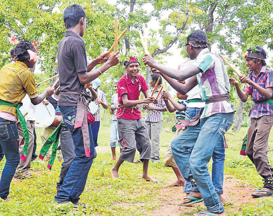 Rich Culture: Karnataka Janapada Parishat President T Thimme Gowda, ZP President                             B Shivappa, Member H M Kaveri and others at 'Haadi habba' programme organised at                   Chottepare-C B Halli near Virajpet, on Friday. (Right) Tribal kids present a traditional dance at the programme. DH Photos