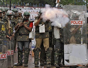 A police officer fires teargas to disperse Pro-Telangana supporters during a protest in Hyderabad June 14, 2013. The demonstrators were demanding a separate Telangana state carved out of Andhra Pradesh, supporters said. REUTERS