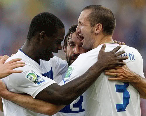 Andrea Pirlo, center, is celebrated by his teammates Mario Balotelli, left, and Giorgio Chiellini after scoring the opening goal during the soccer Confederations Cup group A match between Mexico and Italy at Maracana stadium in Rio de Janeiro, Brazil, Sunday, June 16, 2013. (AP Photo)
