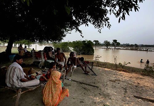 Flood affected people at a relief camp along the swollen Yamuna River near Kashmiri Gate in New Delhi on Friday. PTI Photo.