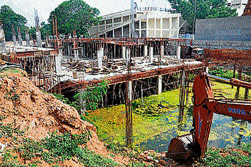 (Left) Algae infested rain water accumulates at the basement parking area of Town Hall, due to incomplete works. dh photo