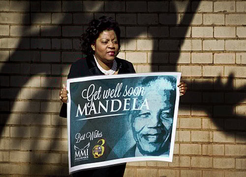 A wellwisher carrying get-well placard arrives at the Mediclinic Heart Hospital where former South African President Nelson Mandela is being treated in Pretoria, South Africa Sunday, June 16, 2013. South Africa's president says that Nelson Mandela is seeing sustained improvement from the recurring lung infection that is forcing him to spend a ninth day in the hospital. AP photo