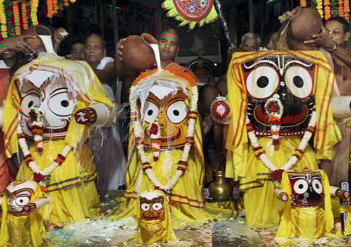 Priests pour milk on deities of Lord Jagannath, Balabhadra and Devi Subhadra during Maha Snana Purnima (bathing festival of Lord Jagannath) at Bhubaneswar Iskcon temple in Bhubaneswar on Sunday.PTI photo.