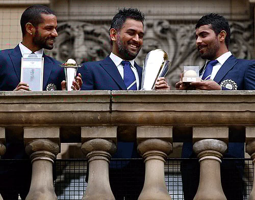 India's cricket players Shikhar Dhawan (L), Mahendra Singh Dhoni (C) and Ravindra Jadeja pose with the ICC Champions Trophy on the balcony of the City Council building in Birmingham, central England, June 24, 2013. REUTERS.