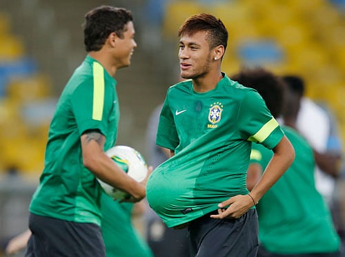 Brazil's player Neymar (R) jokes with a ball next to teammate Thiago Silva during a training session in Rio de Janeiro June 29, 2013. Neymar has been included on a six-man shortlist for the FIFA Confederations Cup Golden Ball award. REUTERS