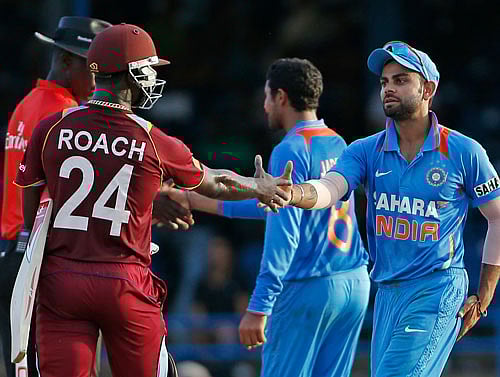 India acting captain Virat Kohli, right, shakes hands with West Indies' Kemar Roach at the end of their Tri-Nation Series cricket match in Port-of-Spain, Trinidad, Friday, July 5, 2013. India won by 102 runs under the Duckworth/Lewis method. AP Photo