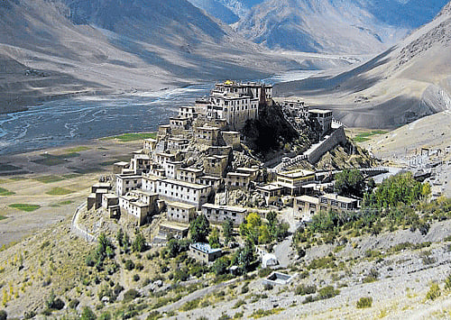 At peace (Clockwise) The Dhankar Monastery; Spiti river, surrounded by mountains; colourful prayer flags.