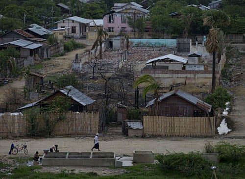 Original In this May 25, 2013 photo, Buddhist women wash clothes at a roadside common well in the foreground of ruins of the Mingalar Zayone Islamic Boarding School and its green boundary wall, background in Mingalar Zayone neighborhood, Meikhtila. Twenty-five Buddhists were sentenced to as many as 15 years in prison for murder and other crimes during a night of rioting, burning and killing in central Myanmar, following weeks in which it seemed only Muslims were being punished for sectarian violence that was aimed primarily at members of their own religion. But the sentences issued Wednesday and Thursday, July 11. 2013, did not erase a sense of unequal justice: A day earlier, a Muslim received a life sentence for murdering one of the 43 people killed March 20 and 21 in the central Myanmar town of Meikhtila. (AP Photo/Gemunu Amarasinghe)