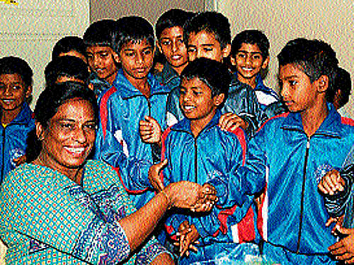 Legendary sprinter P T Usha poses for a photograph with budding athletes at Mangala Stadium in Mangalore on Sunday. DH photo
