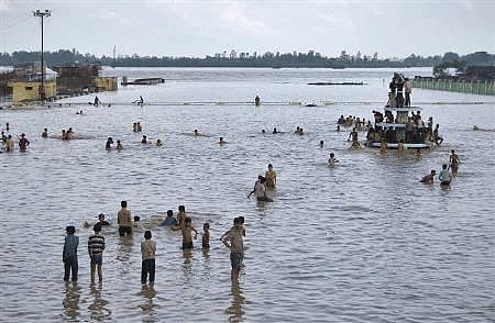 Local residents stand on a flooded road after heavy monsoon rains at Moradabad in Uttar Pradesh September 20, 2010. Reuters