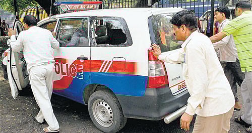 Cops push a damaged patrol van after a confrontation between the Delhi Police and stunt bikers at Windsor place in NewDelhi on Sunday. PTI