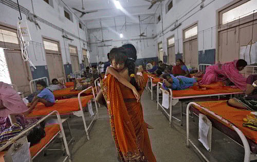 A woman carries her niece who got sick after consuming contaminated meals given to children at a school on Tuesday, in the eastern Indian city of Patna July 18, 2013. The Indian government announced on Thursday it would set up an inquiry into the quality of food given to school pupils in a nationwide free meal scheme after at least 23 children died in one of the deadliest outbreaks of mass poisoning in years. REUTERS