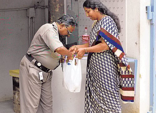 cautious: The security personnel checks the bags of the maids when they enter and leave the apartment block at Harmony Homes in Kalyan Nagar.