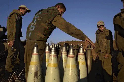 Israeli soldiers handle artillery shells in the Golan Heights, near the border between the Israeli-controlled Golan Heights and Syria, Friday, Aug. 30, 2013. AP photo