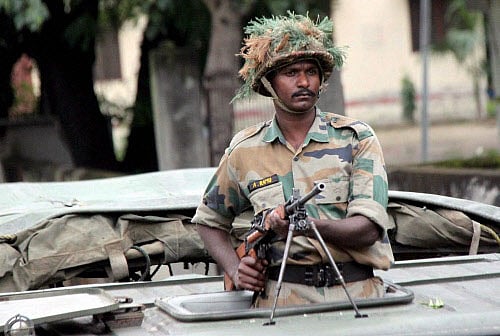 An army trooper during a flag march in the curfew-hit areas in Muzaffarnagar on Sunday. Army was deployed in the curfew clamped area of Muzaffarnagar after communal clashes on Saturday. PTI Photo