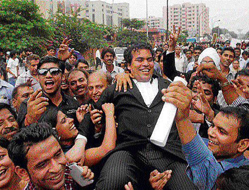 People celebrate with a lawyer outside the Saket District Court after the verdict on the December 16 Delhi gang-rape case in New Delhi on Friday. PTI