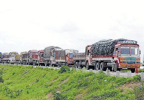 crawling forward: More than 500 trucks were stranded in traffic after rain left massive potholes on the Raichur-Mansalapura highway on Wednesday. dh photo