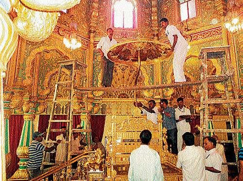 preparations: Workers attached to the office of royal scion Srikantadatta Narasimharaja Wadiyar assemble the Golden Throne, at Mysore Palace, on Sunday. The throne kept in the strong room was offered puja by palace priest Janardhan. It will be kept open for public viewing at durbar hall from October 2. DH PHOTO